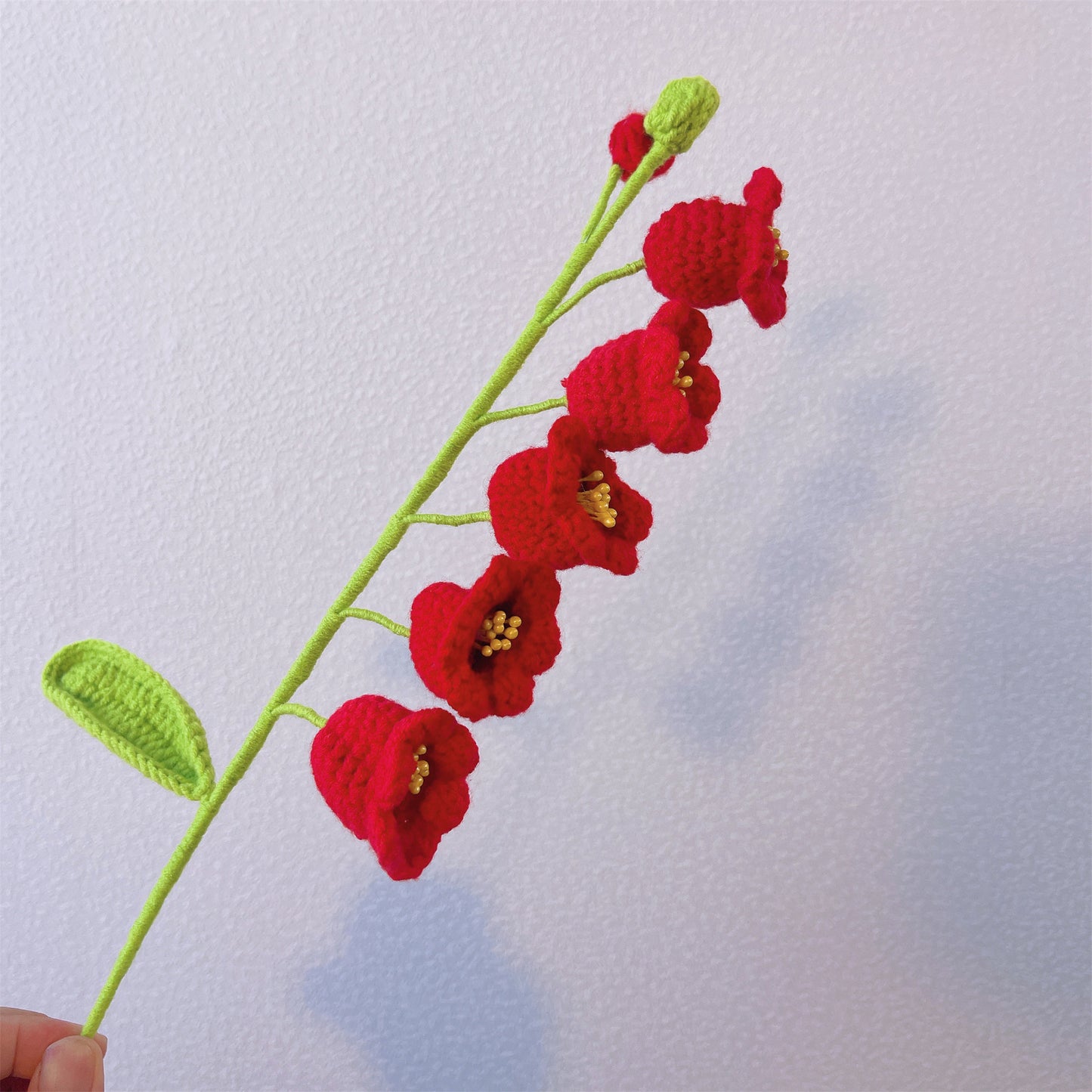 Handgefertigte gehäkelte Blumen zum Hochzeitstag mit weißer Lilie, gelben und roten Tulpen, Sonnenblume, roter Kamelie, rotem Maiglöckchen, burgunderfarbener Pfingstrose und Eukalyptusblättern in Perlenorganza-Verpackung