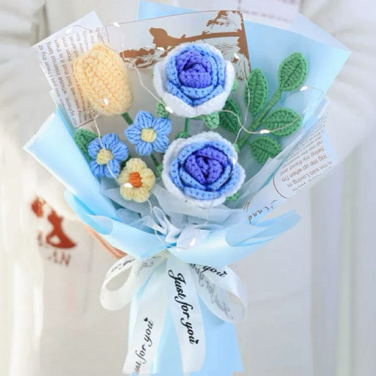 Handgefertigter gehäkelter Blumenstrauß aus blauen Rosen, Lilien, Pompons und Grün