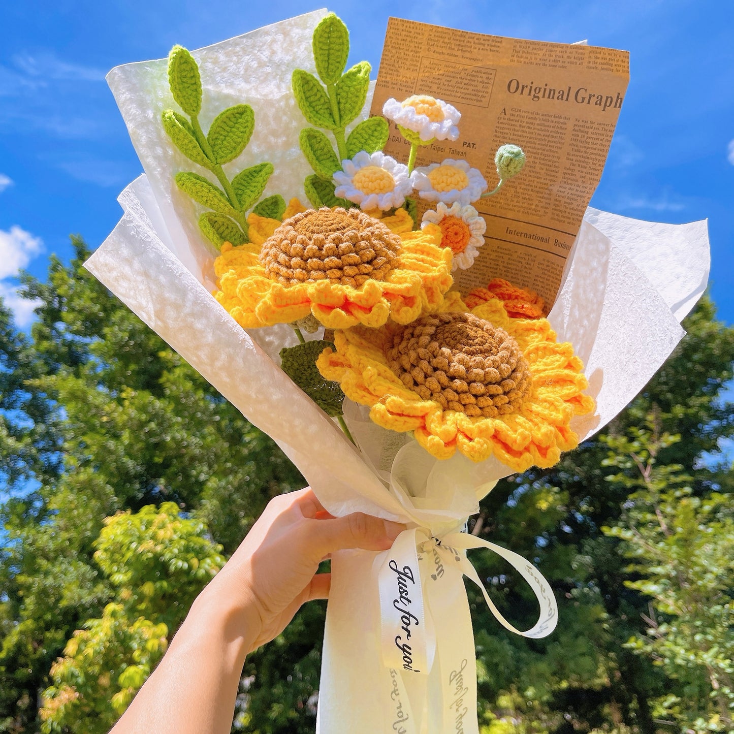 Bouquet de tournesols et de marguerites au crochet fait à la main dans un emballage en papier kraft avec un journal marron pour l'appréciation des vacances d'été