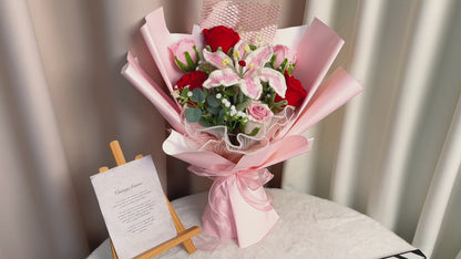 Handgefertigter gehäkelter Pastellstrauß mit großen rosa Rosen, Vergissmeinnicht, Gerbera-Gänseblümchen, olivgrünem Laub und pfirsichfarbenen Akzenten – allergikerfreundlich